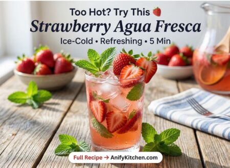 Refreshing strawberry agua fresca with ice, mint and fresh strawberries in glass on wooden table